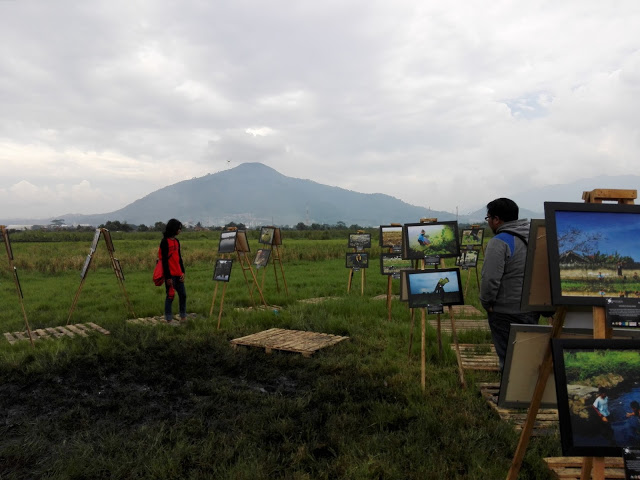 Beberapa pengunjung sedang melihat foto yang dipamerankan oleh Komunitas foto Photospeak's di area pesawahan, Kampung Rancakeong,Desa Linggar,Kecamatan Rancaekek,Kabupaten Bandung, Minggu (5/6/2016). Pameran ini diadakan dalam rangka memperingati Hari Lingkungan sekaligus bentuk simpati atas kerusakan lingkungan akibat limbah pabrik.(Jurnalpos/Restia Aidilla)