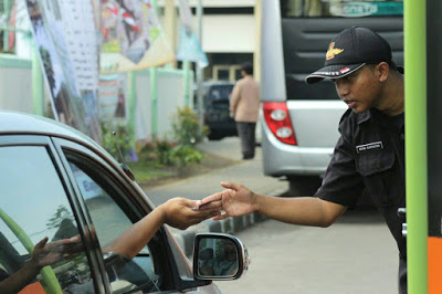 Satpam sedang memberikan karcis pada pengendara mobil saat memasuki kampus UIN Bandung, Sabtu (14/05/2016). Karcis diberlakukan kembali karena hilangnya sejumlah kartu parkir. (Jurnalpos/Pandu Muslim)