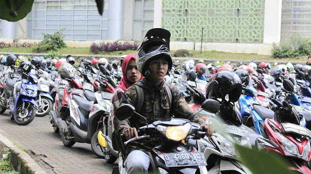 Salah seorang mahasiswa melewati parkiran motor diantara masjid Ikomah dan Aula Abdjan Soelaiman, Rabu(28/09/2015).(Jurnalpos/ Pandu Muslim).