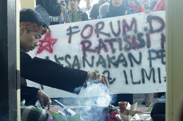 Salah satu demonstran Forum Demokratisasi Kampus (FDK) melakukan aksi ritual membakar dupa di depan Gedung Rektorat UIN Bandung, Jum'at(13/05/2016). Aksi tersebut merupakan tuntutan kebijakan kampus yang belum terealisasi. (Jurnalpos/Pandu Muslim)
