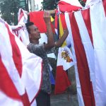 Wawan (32) merapikan bendera dagangannya di Jalan Ahmad Yani, Kota Bandung, Selasa(02/08/2016). (Jurnalpos/Pandu Muslim)