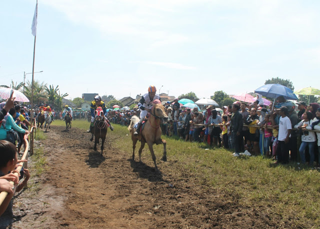 Para peserta Kejuaraan Pacuan Kuda Se-Jawa Barat sedang melakukan balap kuda yang berlangsung di Jalan Gading Tutuka, Soreang, Kabupaten Bandung. Minggu, (31/07/2016). (Jurnalpos/Maulida Madini).