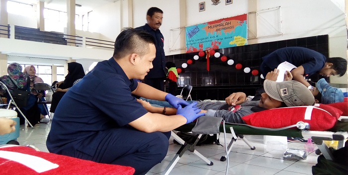 Anggota Palang Merah Indonesia (PMI) Kota Banjar melakukan proses pengambilan darah dari salah satu peserta donor darah dalam acara 'Muamalah Berbagi' yang diselenggarakan oleh Himpunan Mahasiswa Jurusan (HMJ) Hukum Ekonomi Syariah (Muamalah) bidang KPPM, yang berlangsung di Gedung Abdjan Soelaiman, Rabu (03/05/2017). (Lisna/Jurnalposmmedia)