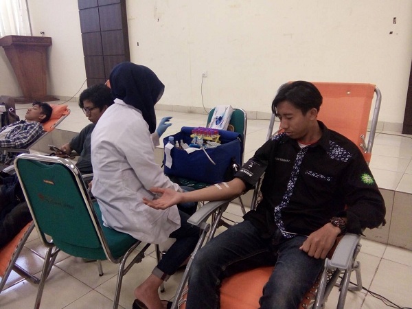 Salah satu pedonor dari kegiatan Donor Darah Physicfair sedang mendonorkan darahnya dengan dibantu petugas. Donor hanya diberikan waktu selama 15 menit setiap orangnya, di Aula Lecture Hall UIN Bandung, Sabtu (23/09/2017). (Neng Nurjanah/Jurnalposmedia)