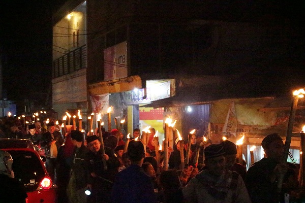 Sejumlah santri Pondok Pesantren Al-Ihsan beserta warga setempat melakukan aksi pawai obor di Jalan Cibiru Hilir, Kecamatan Cileunyi, Kabupaten Bandung, Kamis (21/09/2017). Kegiatan tersebut merupakan rangka memperingati tahun 1 Muharram 1439 H. (Rico Bagus/ Jurnalposmedia)