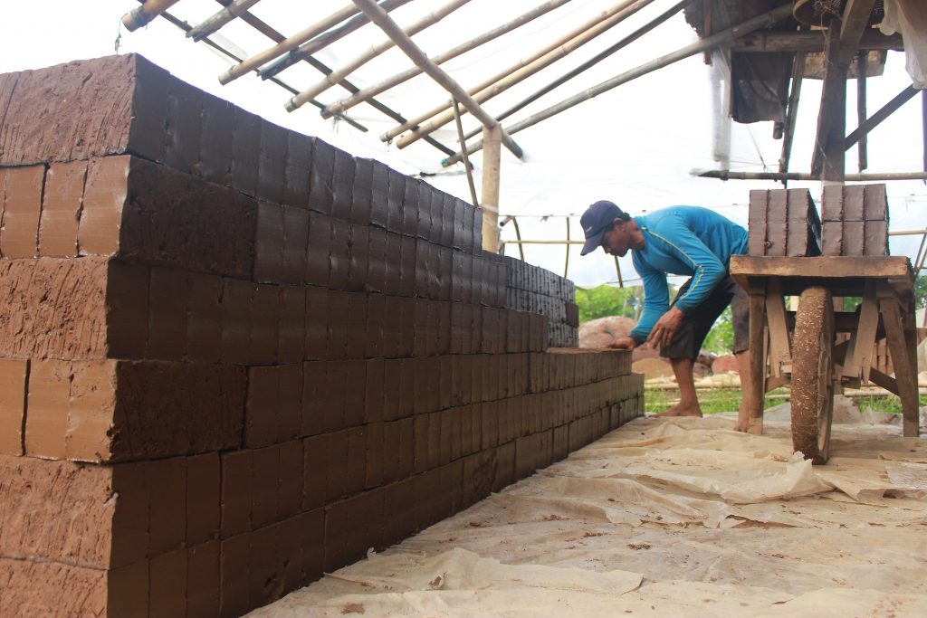 Pekerja mencetak batu bata menggunakan mesin press di kampung Oyod, Desa Racakasumba, Kecamatan Solokan Jeruk, Kabupaten Bandung Selasa (7/11/2017). Intensitas hujan yang tinggi membuat produksi batu bata mengalami penurunan. (Jurnalposmedia/ Reival Akbar)