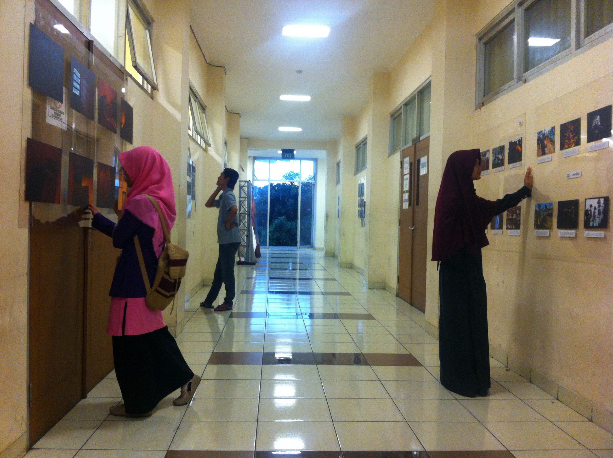 Pengunjung mengamati karya foto yang dipajang dalam Pameran dan Diskusi Foto Anushka oleh Pewarta Foto Indonesia (PFI) Bandung di lorong Student Centre UIN Bandung, Senin (4/12/2017). Pameran tersebut menampilkan sebanyak 40 karya foto jurnalistik yang terdiri dari foto tunggal dan foto seri. (Jurnalposmedia/ Tamara Hani Nurjanah)