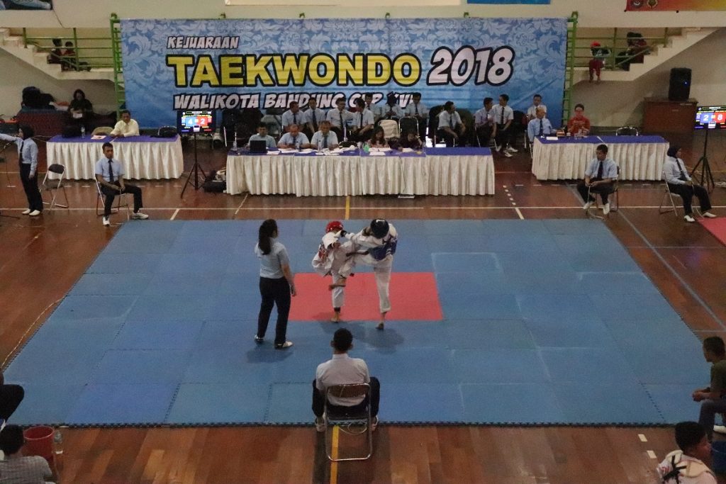 Dua atlet taekwondo saling beradu ketangkasan dalam kejuaraan Taekwondo Walikota Bandung Cup XVI di Gor Arcamanik, Kota Bandung, Jum’at (12/01/2018). Kejuaraan tersebut berlangsung hingga 14 Januari mendatang. Dengan memperlombakan kategiru Kyorugi (tarung) dan Poomsae (seni gerak) usia muda hingga dewasa untuk putera dan puteri.(Rico Bagus/Jurnalposmedia)